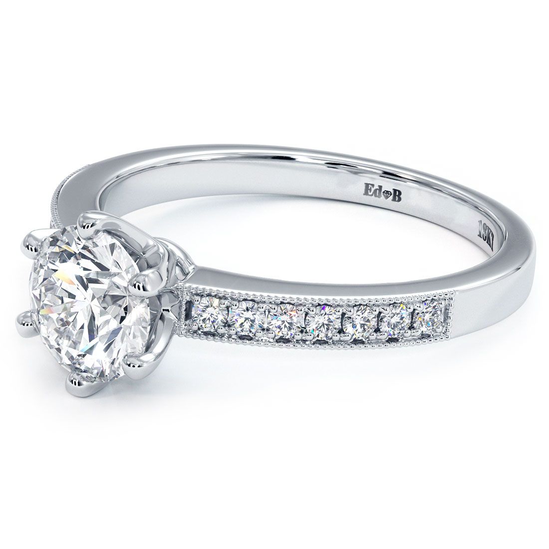 Angled shot of round brilliant 6-prong diamond ring setting in 18k white gold, featuring 0.16ctw micropavé G/SI1 side stones and fine milgrain detail. A timeless engagement ring style from Global Sky Diamonds, Diamond District NYC, 44 West 47th Street Booth GF-10. Center stone not included. View more at globalskydiamond.com