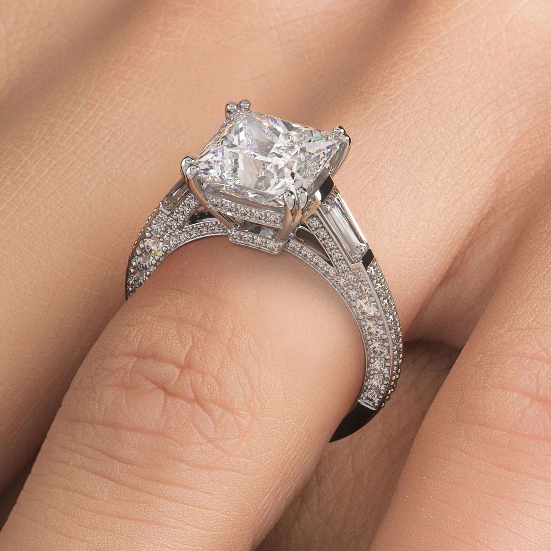 Princess cut diamond engagement ring on hand, featuring double prongs, side tapered baguettes, and a split shank micropavé design in 18KT white gold. Ideal for a 3.0ct center stone. Elegant, three-stone setting handcrafted for brilliance. Shop at Global Sky Diamonds, 44W 47th St Booth GF-10, Diamond District NYC. globalskydiamond.com @globalskydiamonds @global.sky.diamond