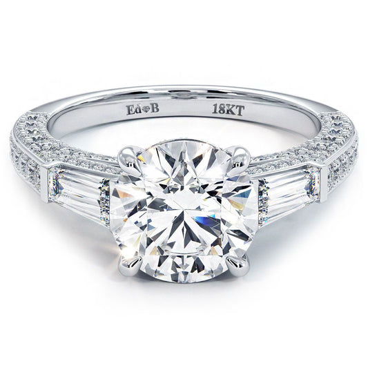 Close-up of a 3-stone engagement ring setting in 18k white gold featuring a round center stone with tapered baguette diamonds and micropavé accents on the band, sold unset, from Global Sky Diamonds, 44W 47th St GF-10, Diamond District, globalskydiamond.com